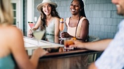two women laughing with cocktails